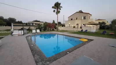 a swimming pool in front of a house at Villa Alex in Tavronitis