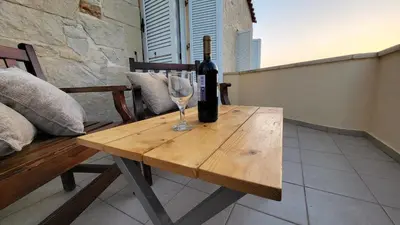 a bottle of wine sitting on a wooden table with a wine glass at Villa Alex in Tavronitis