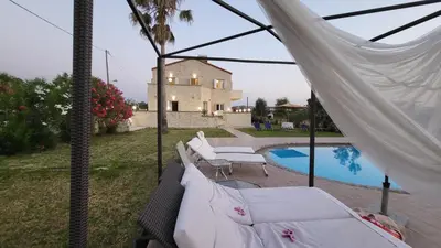 a patio with a hammock and a swimming pool at Villa Alex in Tavronitis