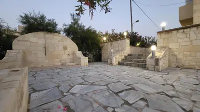 a stone courtyard with a stone wall and stairs at Villa Alex in Tavronitis