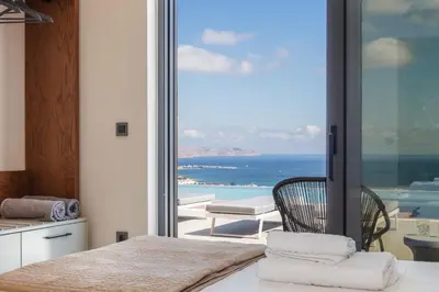 a bedroom with a bed and a view of the ocean at Magical new luxury villa Camellia! in Kissamos