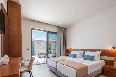 a bedroom with a bed and a desk and a window at Magical new luxury villa Camellia! in Kissamos