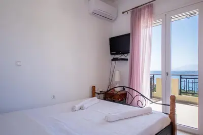 a bedroom with a bed and a large window at Souda Bay View with Private Pool near Chania City in Chania Town