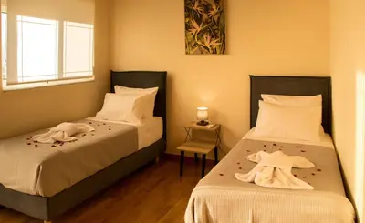 a bedroom with two beds with towels on them at Searenity Home in Ropanianá