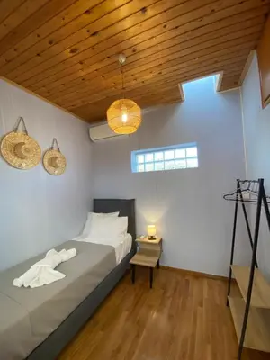 a bedroom with a bed and a wooden ceiling at Searenity Home in Ropanianá