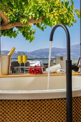 a table with two glasses of wine on a boat at Boutique house Romantza in Kallithea-Voukolies