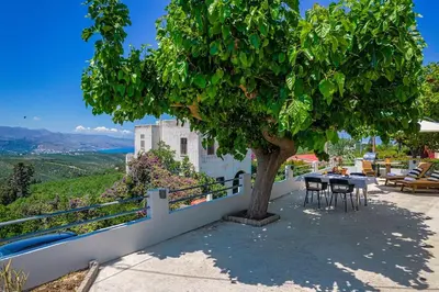 a table and chairs under a tree on a patio at Boutique house Romantza in Kallithea-Voukolies