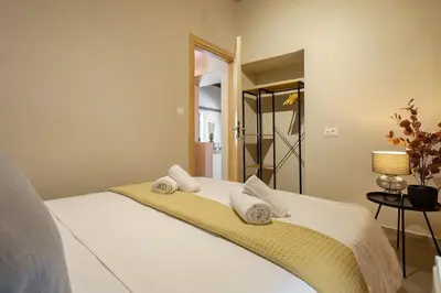a bedroom with a white bed with towels on it at Boutique house Romantza in Kallithea-Voukolies