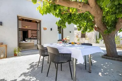 a white table and chairs sitting under a tree at Boutique house Romantza in Kallithea-Voukolies