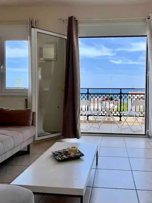 a living room with a couch and a large window at Sea View Apartment #2 in Stalos