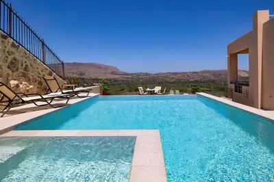 a swimming pool with a view of a house at Iconic Villa with private pool and sea view in Próvarma