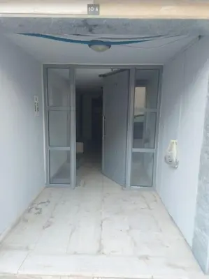 an empty room with glass doors in a building at Koum Kapi 1st floor apt in Chania Town