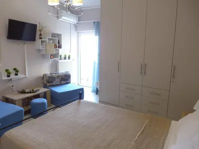 a bedroom with a bed and a chair and a cabinet at Koum Kapi 1st floor apt in Chania Town