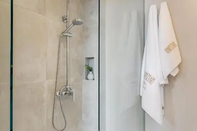 a bathroom with a shower with a glass door at Harismari Cozy Hotel in Chania Town