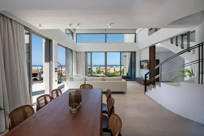 a dining room and living room with a table and chairs at Villa Manu Luxury Living in Stalos