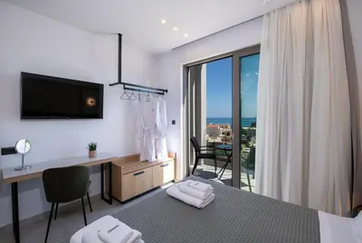 a bedroom with a bed and a desk and a window at Villa Manu Luxury Living in Stalos