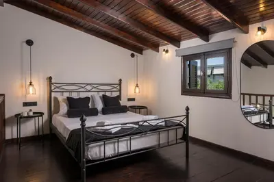 a bedroom with a large bed and a window at Eightyfour Living with private pool in Chania Town