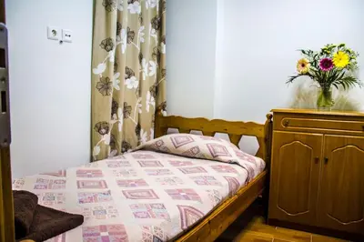 a bedroom with a bed and a vase of flowers on a dresser at Nelly's House in Chania Town