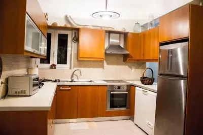 a kitchen with wooden cabinets and a stainless steel refrigerator at Nelly's House in Chania Town