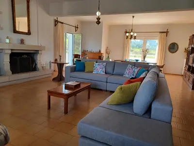a living room with a blue couch and a fireplace at Casa Dastele remarkable seaview 5' from the sea in Chania Town