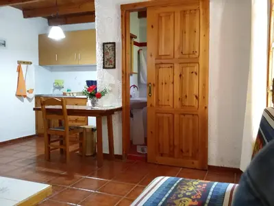 a kitchen and dining room with a table and a door at Olive tree Cottages in Palaiochóra