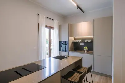 a kitchen with a counter and some chairs in it at In Heart of Old Town Saint Rocco's Chic Apt in Chania Town