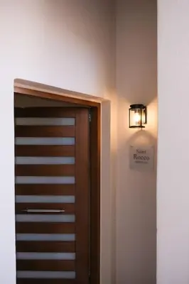 a wooden door in a room with a light on the wall at In Heart of Old Town Saint Rocco's Chic Apt in Chania Town