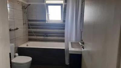 a bathroom with a tub and a toilet and a window at Elena Apartments in Kato Daratso