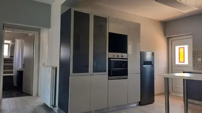 a kitchen with a refrigerator and a table at Elena Apartments in Kato Daratso