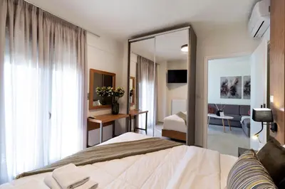 a hotel room with a bed and a mirror at Elia Beach Deluxe Apartment in Chania Town