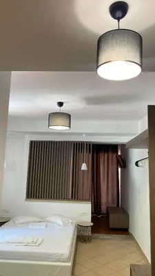 a bedroom with a bed and two lights on the ceiling at Emerald Suites in Vryses