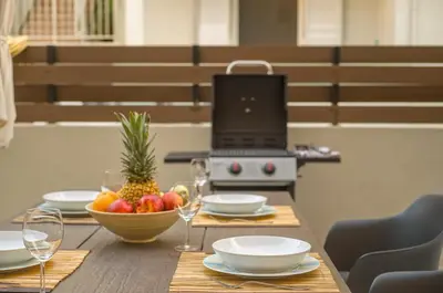 a table with a bowl of fruit and a laptop at JasmineStay - Two bedroom apartments with backyard in Chania Town