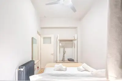 two beds in a room with white walls at JasmineStay - Two bedroom apartments with backyard in Chania Town