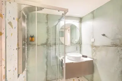 a bathroom with a shower with a sink and a mirror at JasmineStay - Two bedroom apartments with backyard in Chania Town