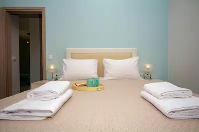 a bed with white pillows and a tray with a candle on it at Korfali Apartments in Kissamos