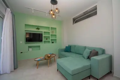 a living room with a blue couch and a table at Korfali Apartments in Kissamos