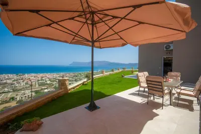 a patio with a table and an umbrella at Korfali Apartments in Kissamos