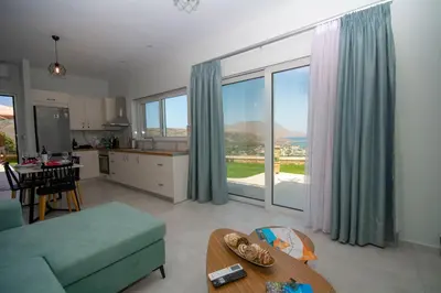 a living room with a couch and a table and a kitchen at Korfali Apartments in Kissamos