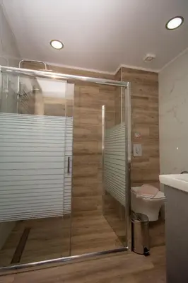 a glass shower in a bathroom with a toilet at Korfali Apartments in Kissamos