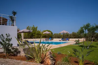 a swimming pool with umbrellas in a yard at Al Aker Villa with private pool in Kalathas