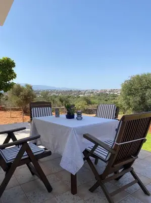 a table and chairs on a patio with a view at Al Aker Villa with private pool in Kalathas