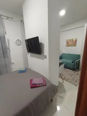 a bedroom with a bed and a tv on a wall at Ethereum City Αpartment - Suite in Chania Town