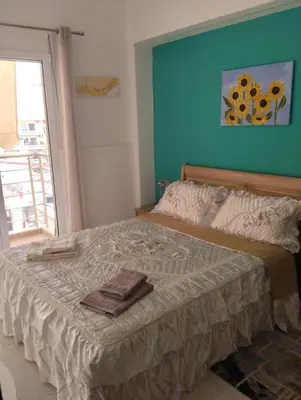 a bedroom with a large bed with a blue wall at Ethereum City Αpartment - Suite in Chania Town
