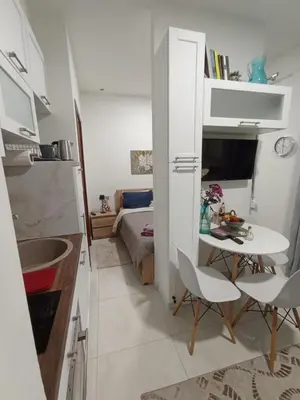 a small kitchen with a small table and a room with a bed at Ethereum City Αpartment - Suite in Chania Town