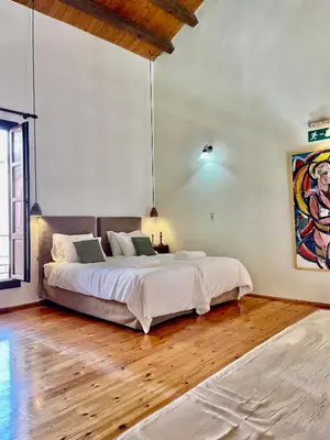 a bedroom with a large bed and a wooden floor at Erietta Suites in Chania Town