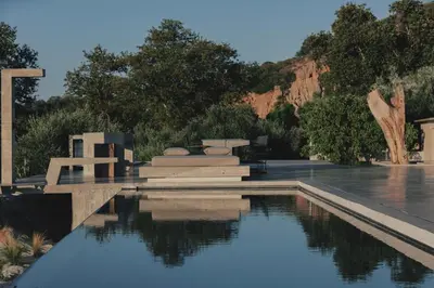 a pool of water with a bridge and trees at Inspiration House in Souda