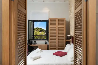 a bedroom with two beds and a window at The Alma City Suites in Chania Town
