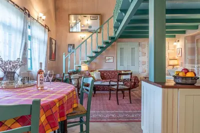 a dining room with a table and a staircase at Thimari Gardens in Chania Town