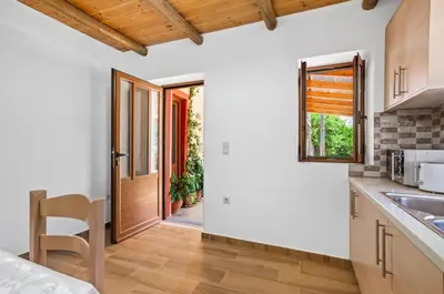 a kitchen with a door leading to a yard at Maria's House with View in Kambos in Kámbos