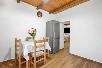 a kitchen and dining room with a table and a refrigerator at Maria's House with View in Kambos in Kámbos